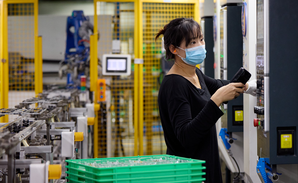 组件制造工厂的一名员工正在操作机器